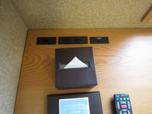 JR九州ホテルブラッサム大分 ダブルルーム デスク回り左側 有線LANとコンセント、デスク灯のスイッチがあります