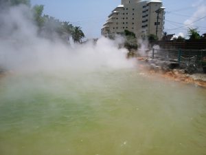 鉄輪温泉 地獄めぐり 鬼山地獄 琥珀色のお湯に蒸気が噴出しています