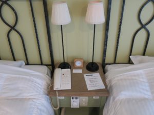 草津温泉 ホテルヴィレッジ タワー棟ツイン ベッドサイドテーブル 電話と目覚まし時計、コンセントがあります