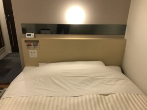 スーパーホテル 東京・芝 シングルルーム ベッド セミダブルサイズのベッドが置いてあります