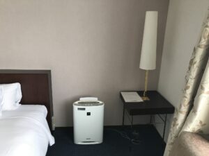京成ホテルミラマーレ モデレートツイン ベッド横 加湿空気清浄機とテーブル、照明があります
