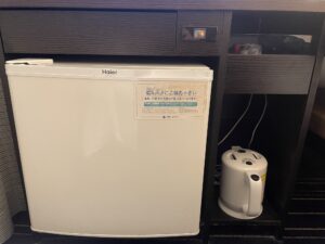 アパホテル 京成成田駅前 シングルルーム デスク下 冷蔵庫と紙コップ、電気ポットがあります