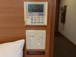 ドーミーイン新潟 ダブルルーム 枕元 コンセントとエアコン、照明のスイッチがあります
