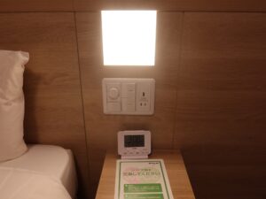 ドーミーイン広島ANNEX ダブルルーム 枕元 照明のスイッチとACコンセント、USBポート、目覚まし時計があります