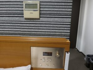 アパホテル 千葉八千代緑が丘 シングルルーム エアコンと明かりのスイッチと目覚まし時計、非常灯