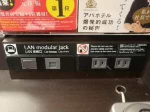 アパホテル 京都駅堀川通 シングルルームB デスク上 明かりのスイッチ、有線LANポート、ACコンセントがあります