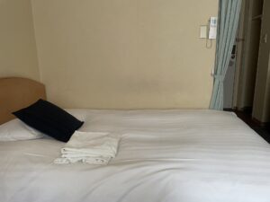 ホテルハーバー横須賀 シングルルーム ベッドとエアコンのリモコン