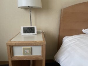 ホテルハーバー横須賀 シングルルーム サイトテーブル 明かりと目覚まし時計、テーブルタップが置いてあります