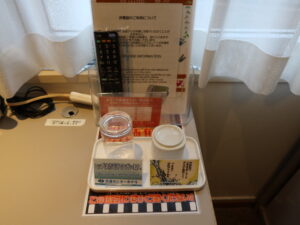 青森センターホテル シングルルーム デスク右側 テーブルタップ・テレビのリモコン・グラス・湯飲茶碗があります